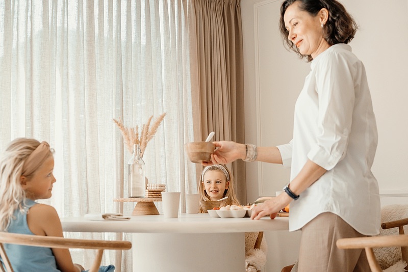 Family assistant helping a girl at the table