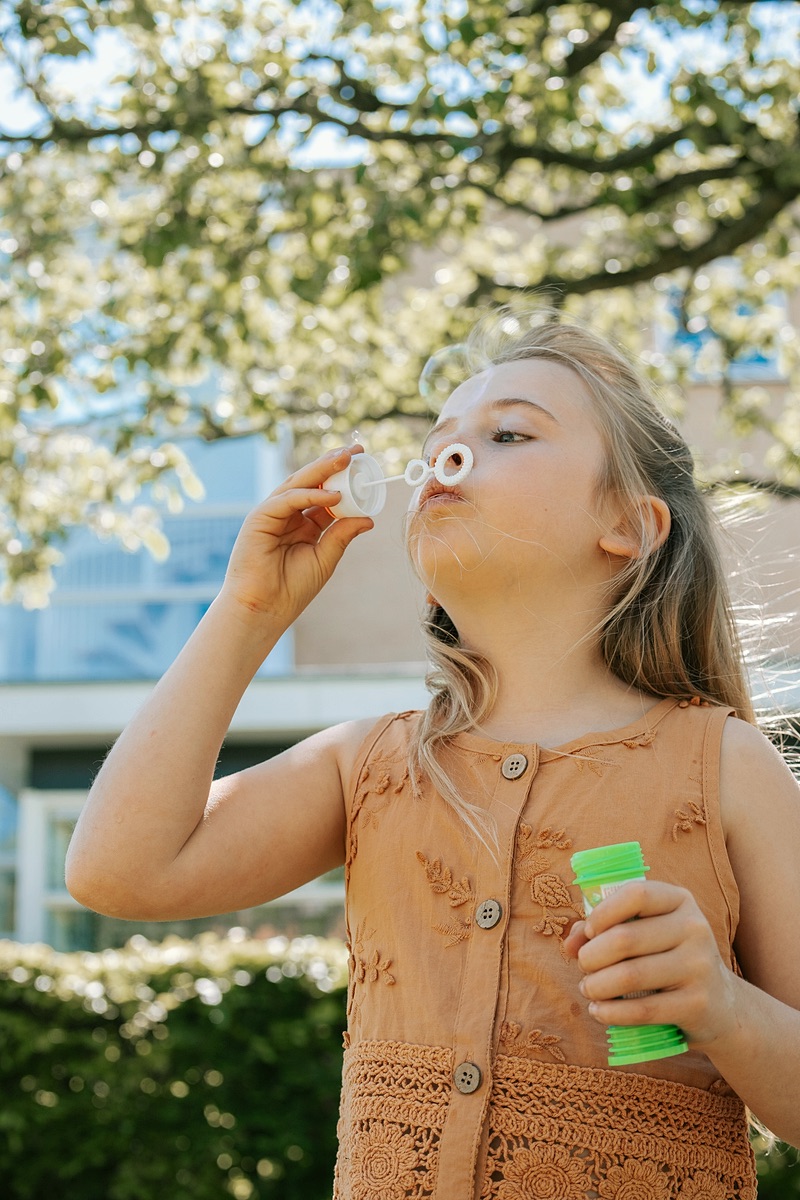 Child blowing bubbles in the garden