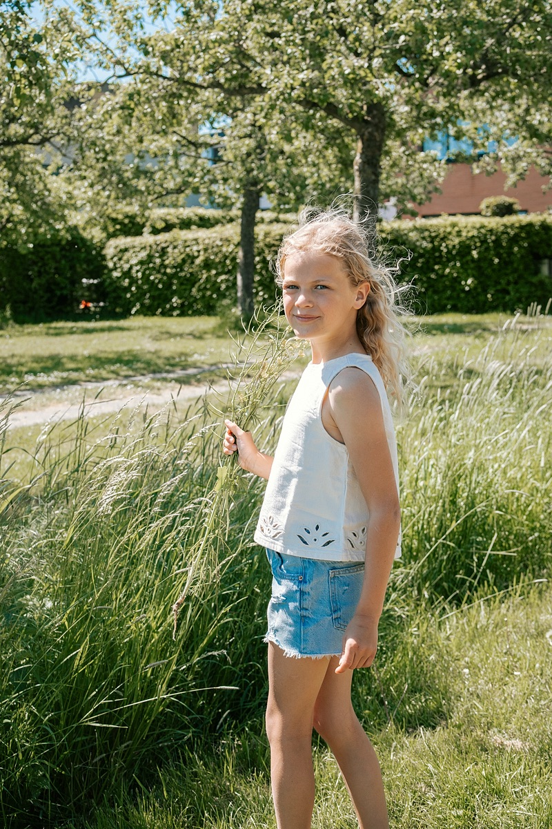 Meisje staat bij het hoge gras