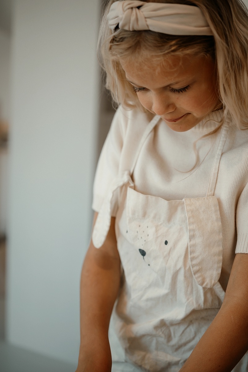 Meisje in een schort in de keuken