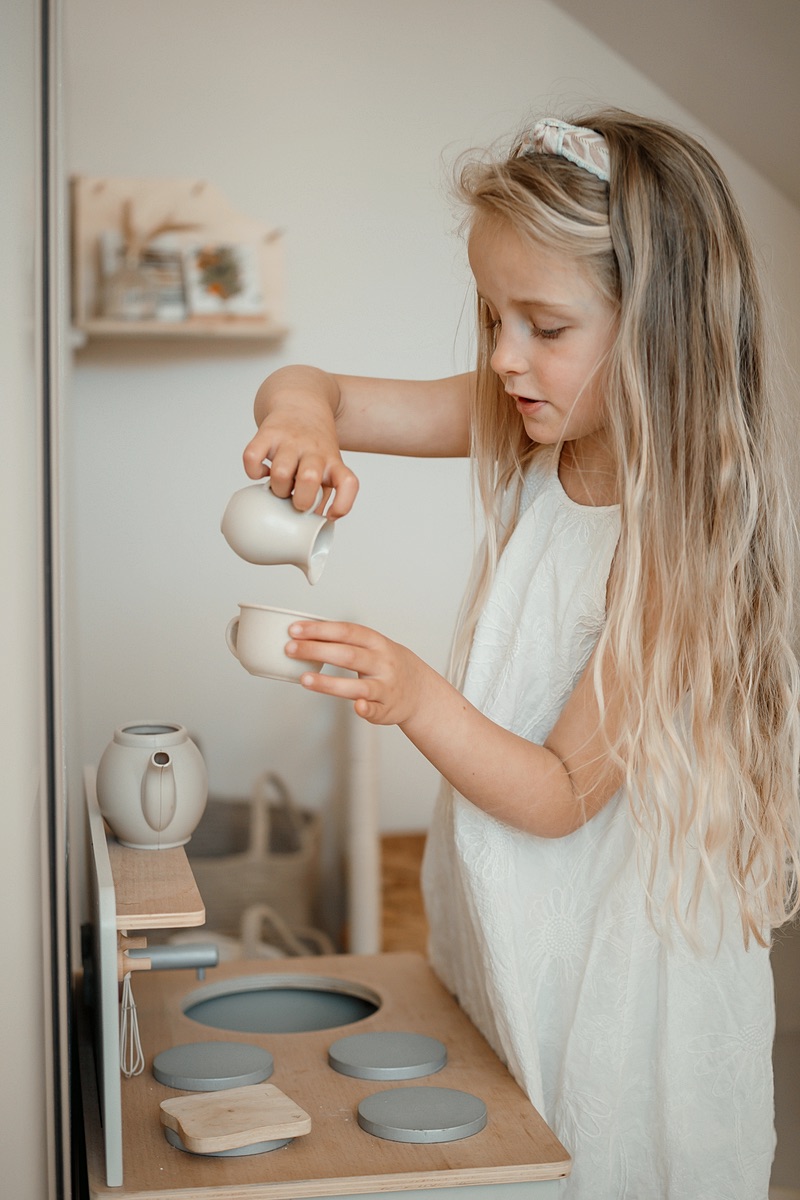 Meisje speelt met een serviesje