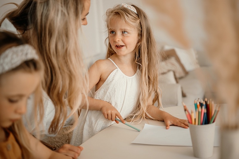 Twee meisjes tekenen samen aan tafel