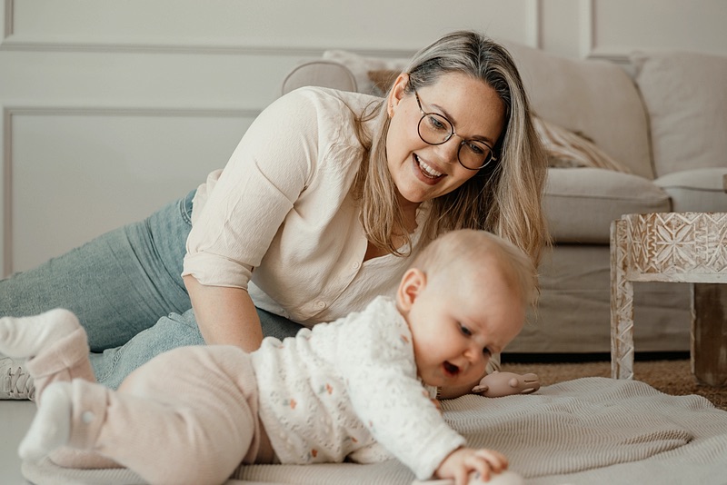 Nanny speelt met een baby op de vloer