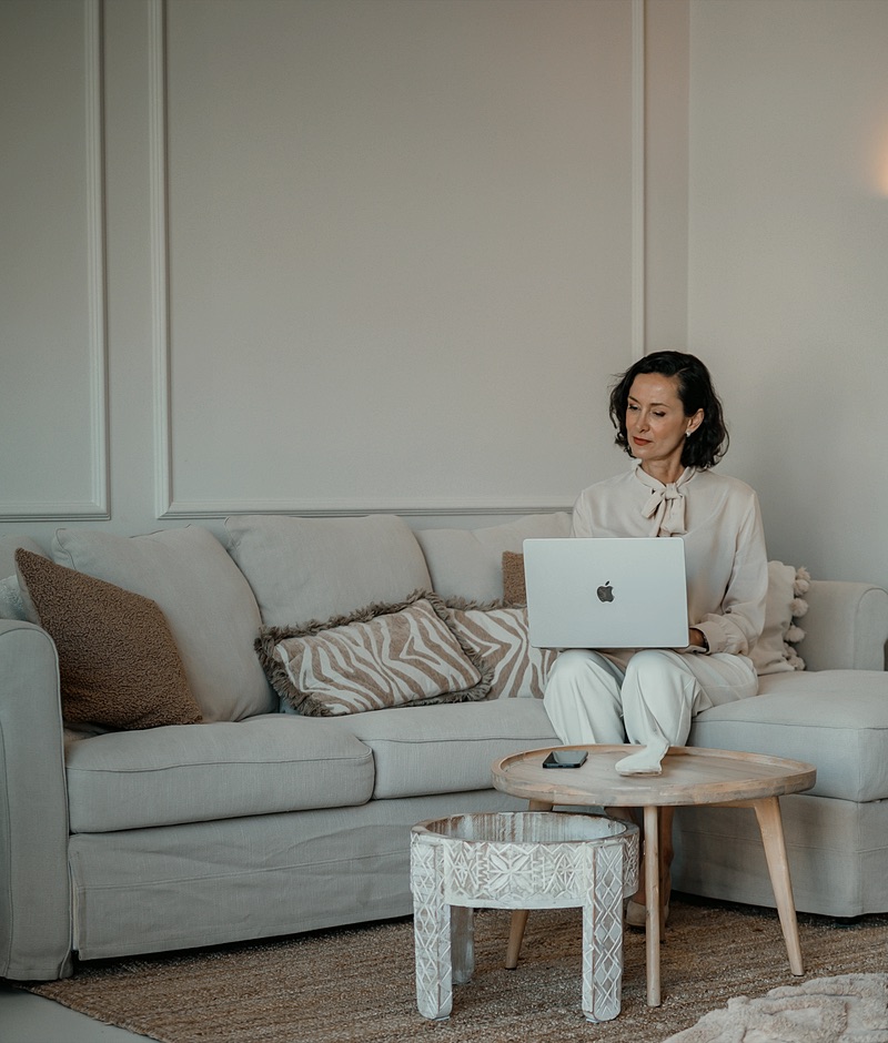 Personal assistant working on her laptop on the sofa