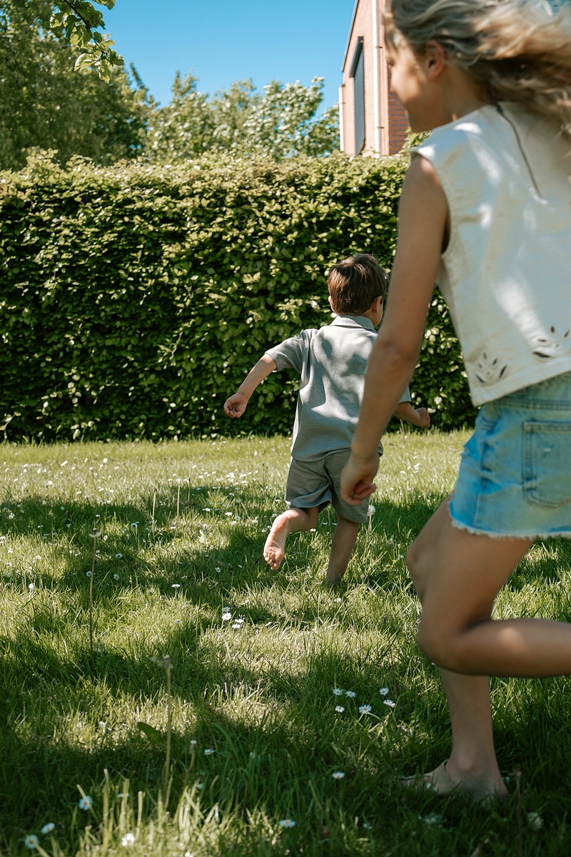 Twee kinderen rennen door de tuin